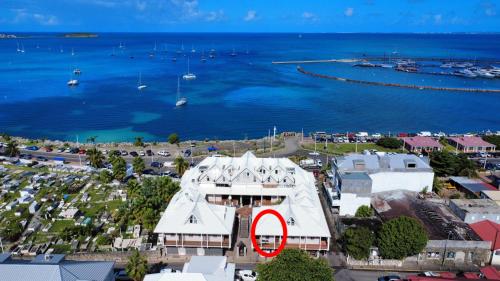 a building with a red circle on it next to the water at 2 bedroom Caribbean charm in Marigot's heart in Marigot