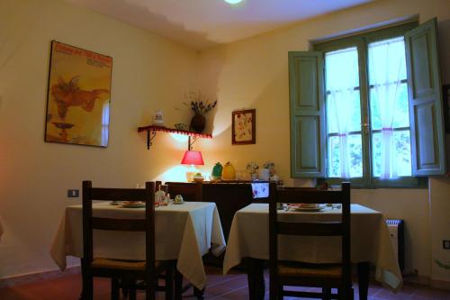 a dining room with two tables and a window at Casa Deimar in Matelica