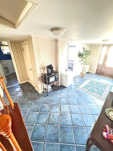 a living room with a blue tile floor and a table at Spacious 3 Bedroom Lakeview Retreat with Private Comfort & Free Parking in Watchung