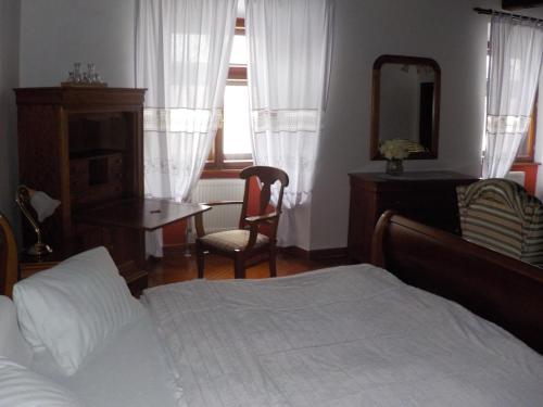 a bedroom with a bed and a table and a mirror at Hotel Kriváň in Kysucké Nové Mesto