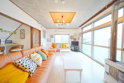 a living room with a couch and a table at 小樽運河まで徒歩7分 小樽のノスタルジックな戸建貸切 Tabiyado in Otaru