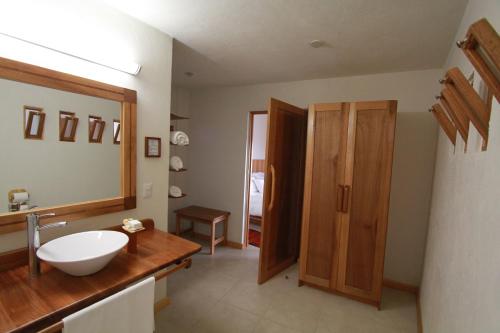 a bathroom with a white sink and a mirror at Casa Tsaya Hotel Boutique in Bernal