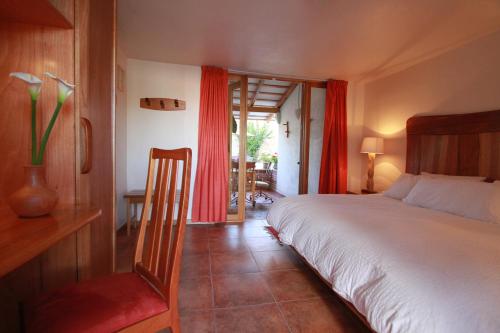 a bedroom with a bed and a window with red curtains at Casa Tsaya Hotel Boutique in Bernal