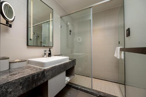 a bathroom with a sink and a glass shower at Atour Hotel Dali Xiaguan Taiye International Plaza in Dali