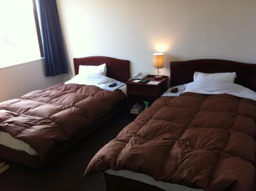 two beds sitting next to each other in a bedroom at Prince Hotel Shimonoseki in Shimonoseki