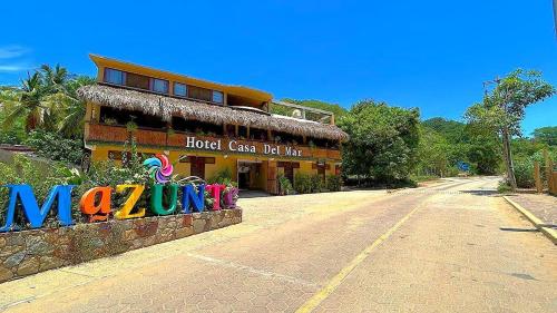 a building with a sign on the side of a street at Hotel Casa del Mar Mazunte in Santa María Tonameca