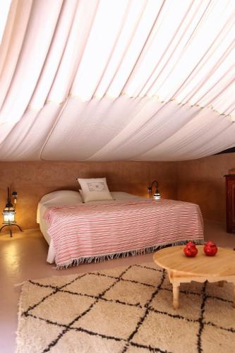 a bedroom with a bed under a roof at La Ferme Berbere Adult only in El Harkat