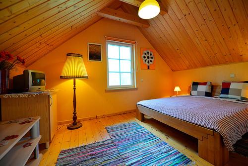 a bedroom with a bed and a lamp and a tv at Provincija in Palanga
