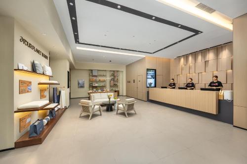 a lobby of a store with two people at a counter at Atour Hotel Dali Xiaguan Taiye International Plaza in Dali