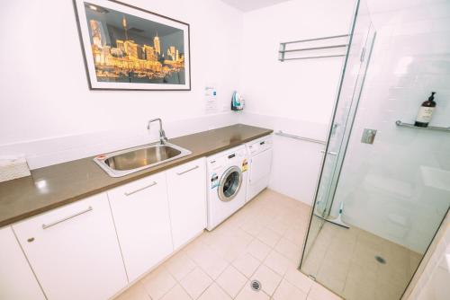 a white kitchen with a sink and a washing machine at SEABREEZE at Victor Harbor in Victor Harbor