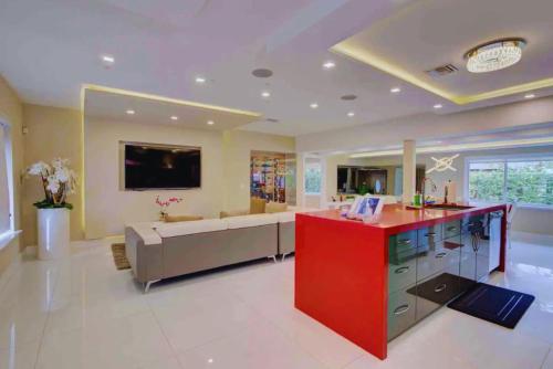 a large living room with a red counter and a couch at The Palms Villa with Cinema, Game Table, Pool, Jacuzzi , Giant Chess, 8 Beds in Miami