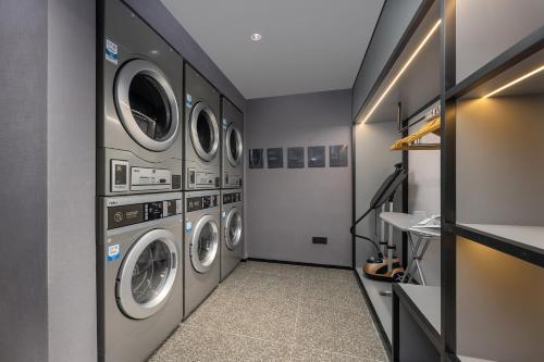 a laundry room with four washer and dryer machines at Atour Hotel Dali Xiaguan Taiye International Plaza in Dali