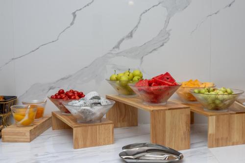 a group of bowls of fruit on wooden stands at Atour Hotel Dali Xiaguan Taiye International Plaza in Dali