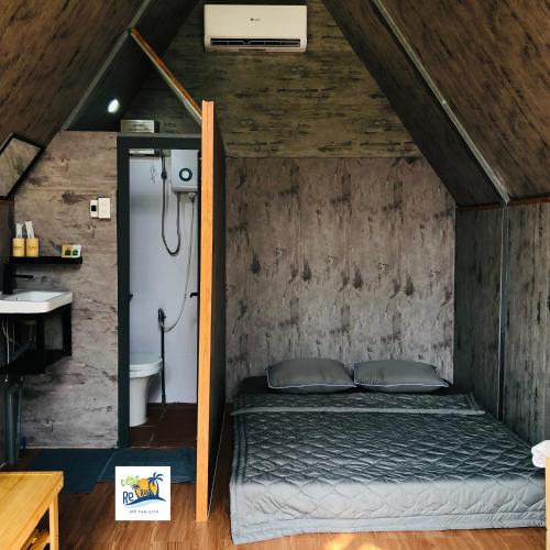 a bedroom with a bed in a attic at Cóc Retreat Mỹ Tho City in My Tho