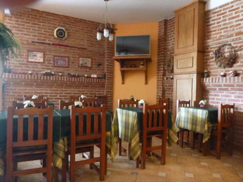 ein Esszimmer mit Tischen und Stühlen und einem Fernseher in der Unterkunft Hosteria del Sur in Villa Gesell