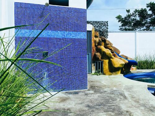 a blue tiled wall next to a swimming pool at Blue Rriver House in Samen