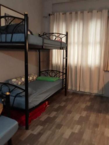 two bunk beds in a room with a window at Bang lumphu house&bistro in Bangkok