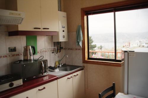 a small kitchen with a sink and a window at El Mirador De Valparaiso in Valparaíso