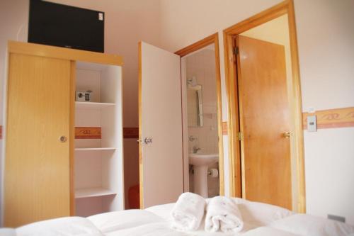 a bedroom with a bed and a bathroom with a sink at El Mirador De Valparaiso in Valparaíso