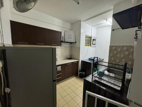 a kitchen with a refrigerator and a sink in it at Homestay Tasik Biru Kundang in Rawang