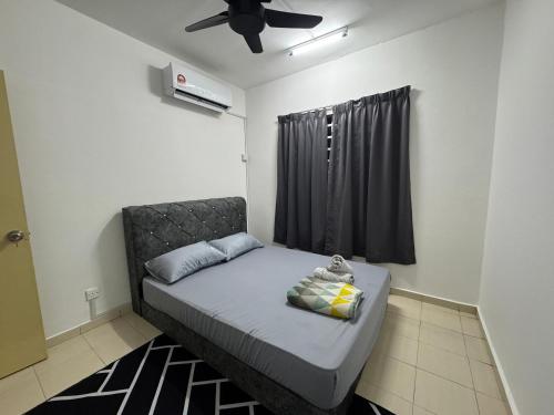 a small bedroom with a bed with a black curtain at Homestay Tasik Biru Kundang in Rawang