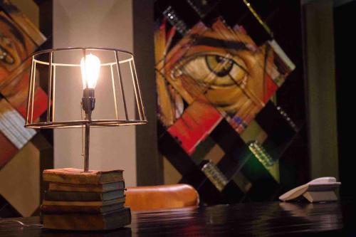 a lamp sitting on top of a wooden table at Othelo Boutique Hotel Mexico in León