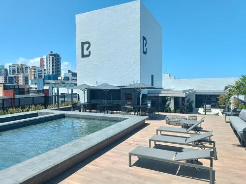 a pool on the roof of a building with lounge chairs at WAY Tambáu - Pé na Areia in João Pessoa