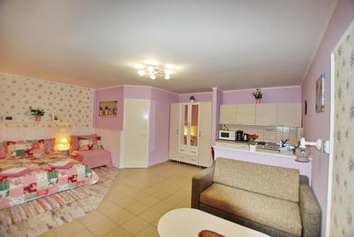 a room with a bed and a couch and a kitchen at Aurora Ház in Zalakaros