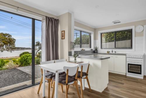 a kitchen and dining room with a table and chairs at 15 Beach St in Merimbula