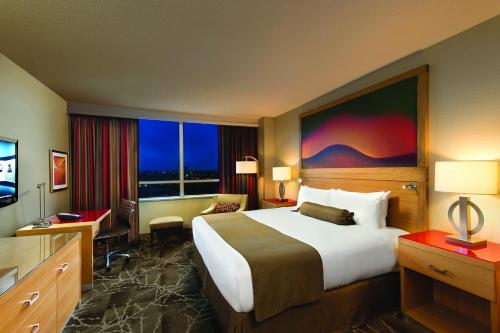 a hotel room with a bed and a large window at River Rock Casino Hotel in Richmond