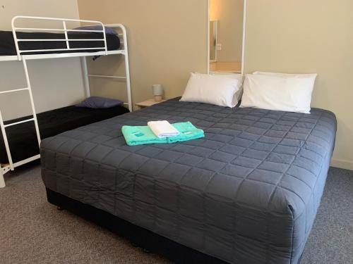 a bed in a room with a bunk bed at Mid Coast Motor Inn in Macksville