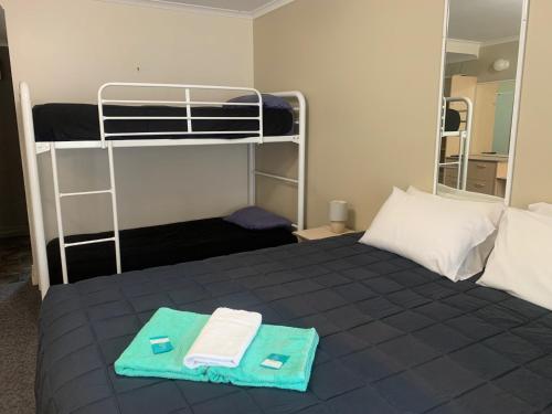 a bedroom with a bed with two bunk beds at Mid Coast Motor Inn in Macksville