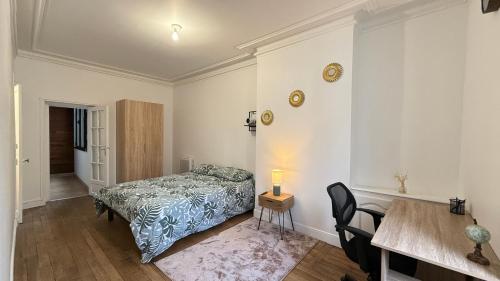 une chambre avec un lit, une table et des chaises dans l'établissement Le carmes - Rétroprojecteur - Hypercentre Orléans, à Orléans