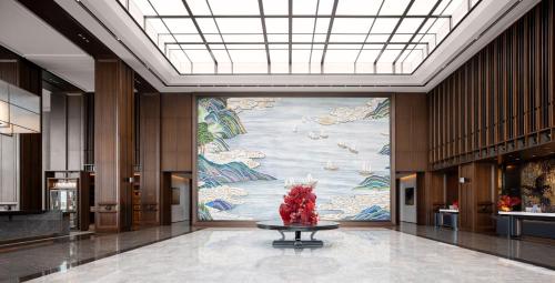 a large mural in a lobby with a table in the middle at 汕头白天鹅酒店 in Batou