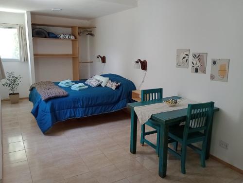 a bedroom with a bed and a table and chairs at Departamento Los Tilos in Mina Clavero