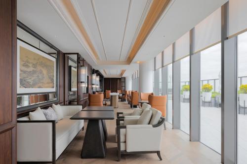 a lobby with couches and tables and windows at 汕头白天鹅酒店 in Batou