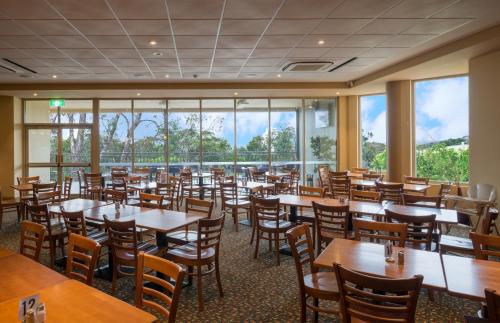 jadalnia ze stołami, krzesłami i oknami w obiekcie Royal Hotel w mieście Springwood