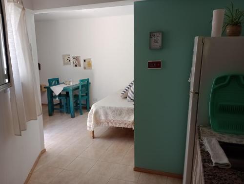 a room with a room with a table and a refrigerator at Departamento Los Tilos in Mina Clavero