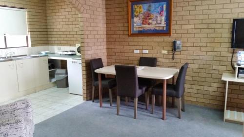 a kitchen with a table and chairs in a room at Sunrise Motel in Barooga