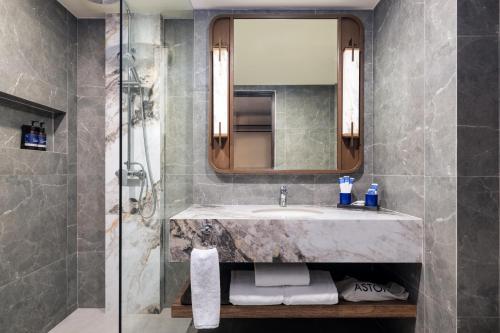 a bathroom with a sink and a shower at Aston Kuta Hotel and Residence in Kuta