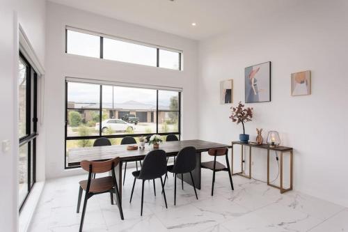 a dining room with a table and chairs at Bright and Chic House at Throsby with 4 Bedrooms in Harrison