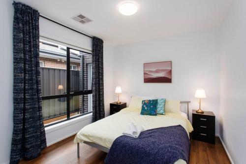 a bedroom with a bed and a large window at Bright and Chic House at Throsby with 4 Bedrooms in Harrison