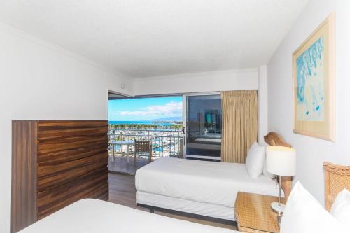 a hotel room with two beds and a balcony at Ilikai Tower 943 Yacht Harbor View 2BR in Honolulu
