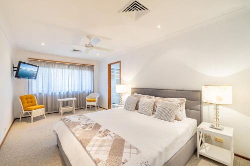 une chambre avec un grand lit et une télévision dans l'établissement 139 Government Rd - Pet Friendly, Air Con, WiFi, Water views, à Nelson Bay