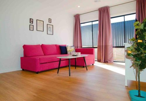 a living room with a pink couch and a table at Brand New Delight Home at Throsby with 4 Bedrooms in Harrison