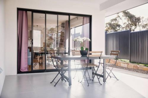 a dining room with a table and chairs at Brand New Delight Home at Throsby with 4 Bedrooms in Harrison