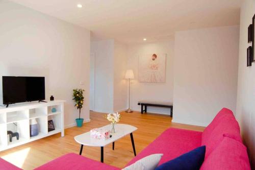 a living room with a pink couch and a tv at Brand New Delight Home at Throsby with 4 Bedrooms in Harrison