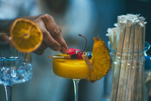 a person is holding a drink with an orange at Jungle Vista Boutique Hotel in Manuel Antonio