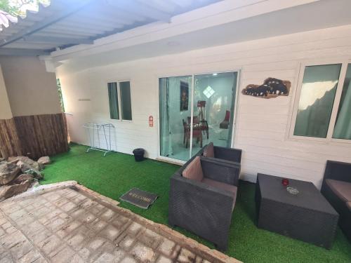 a living room with a couch and green grass at Red Moon Hideaway in Ko Chang