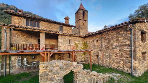 a large stone building with a tower on top at Alojamiento Sant Joan de Fabregues - Rupit i Pruit in Rupit